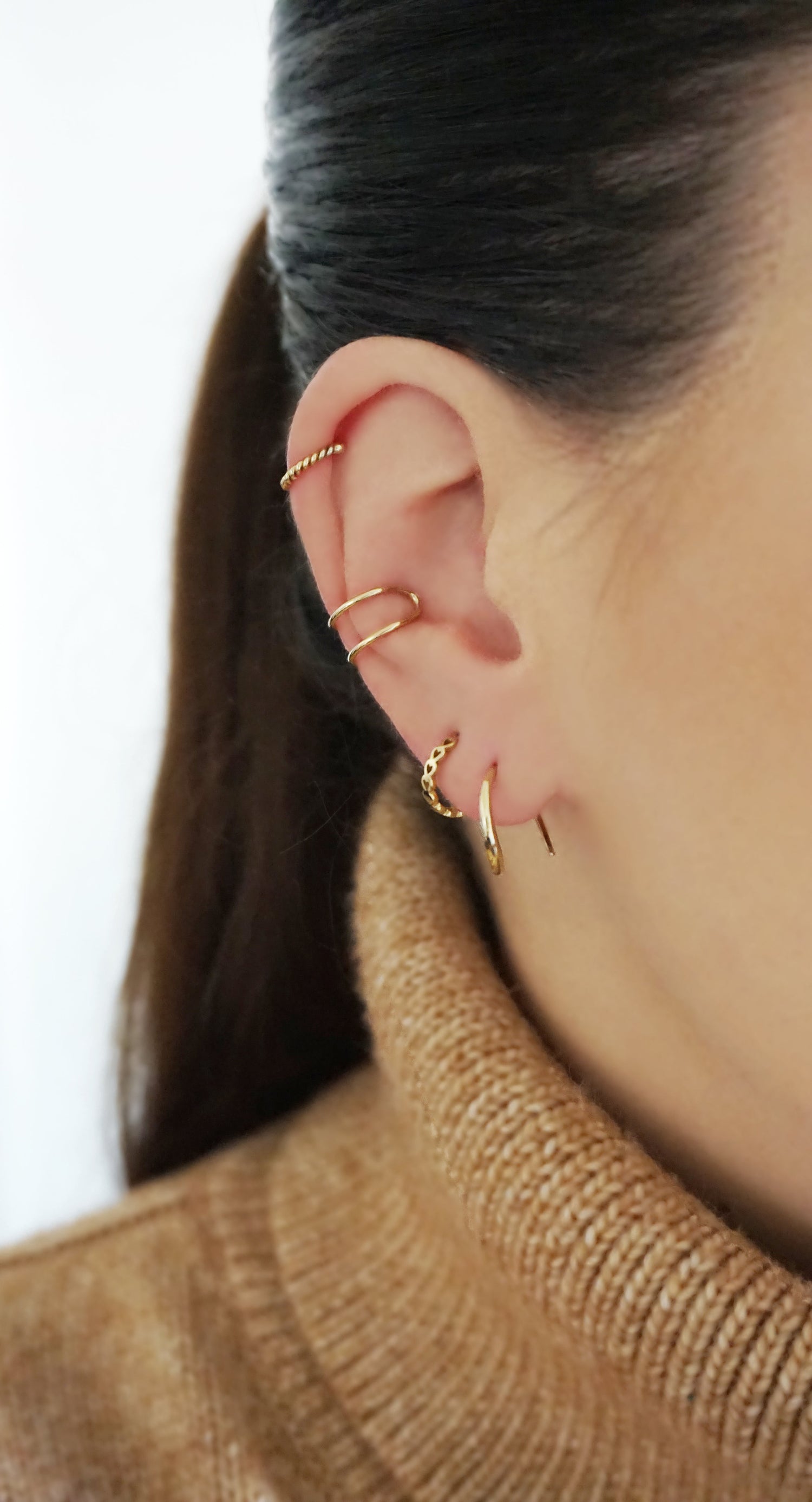 woman wearing a combo of earrings from Whisper Gold's Earrings collection