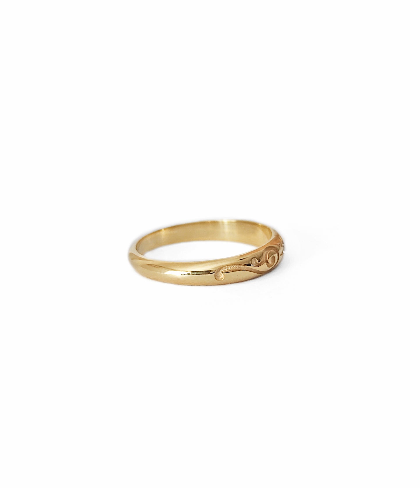 side view of solid yellow gold dome band ring with floral designs and set with a white diamond with a star polaris setting