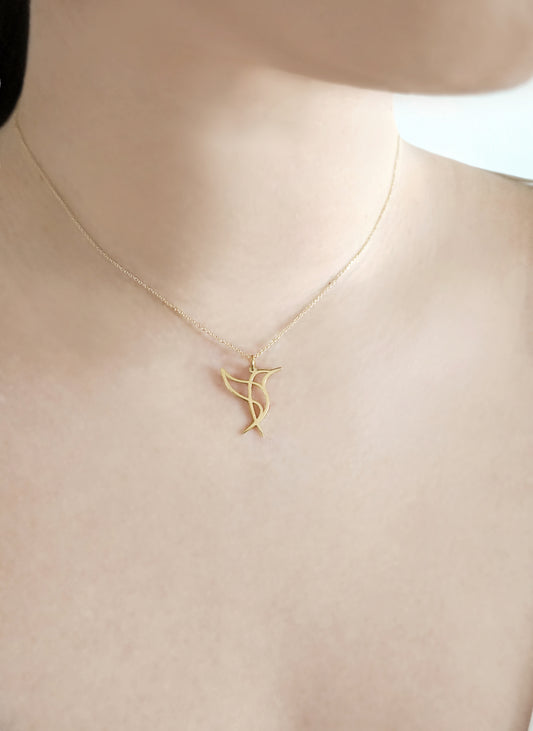 close up of a female's neck wearing a gold necklace with a cutout pendant in the shape of a hummingbird