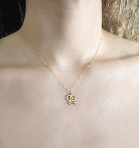 female wearing solid gold necklace with a small double female/venus lesbian symbol pendant