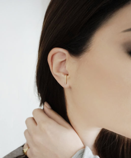 female wearing a solid yellow gold suspender hook cuff earring
