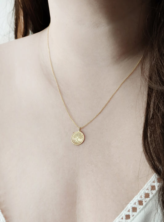 female wearing a yellow gold necklace with a 14mm disc pendant engraved with the Tree of Life