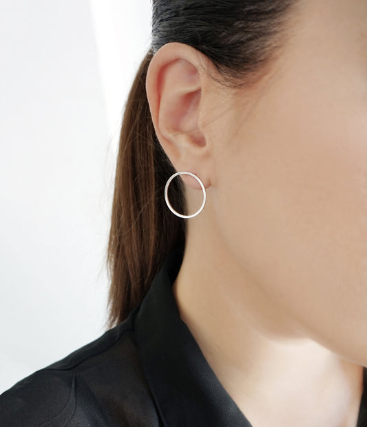 woman wearing open circle hoop stud earrings in solid white gold