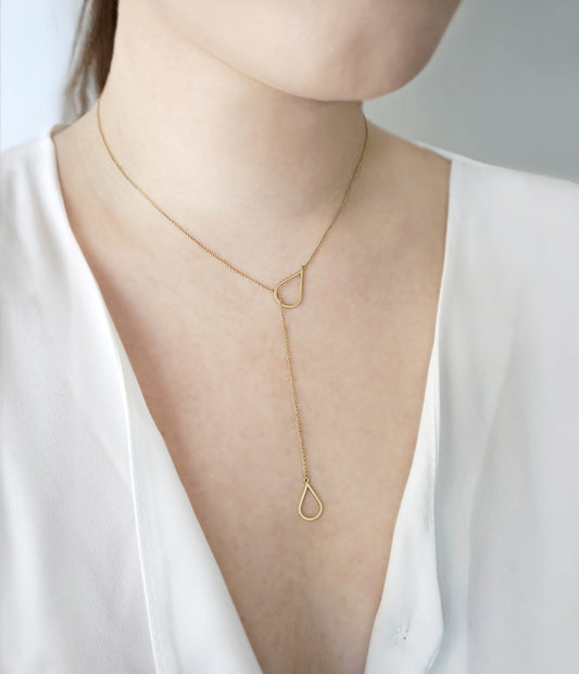 female wearing solid gold lariat y necklace with two teardrops