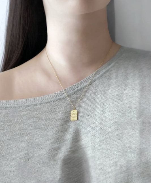 woamn wearing gold octagon pendant necklace personalized with natal chart zodiac signs of the sun the moon and ascendant, a birth date and an alchemy element