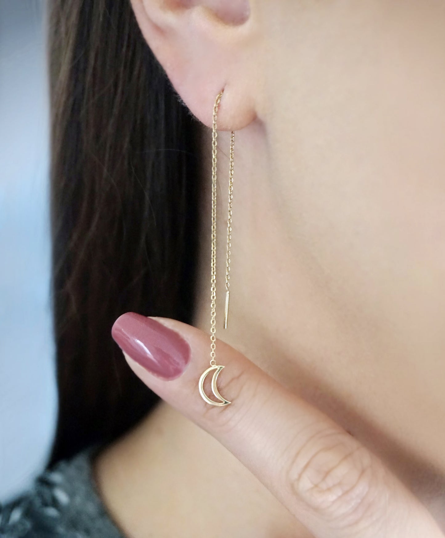woman wearing gold threader pull through earring with tiny a crescent moon