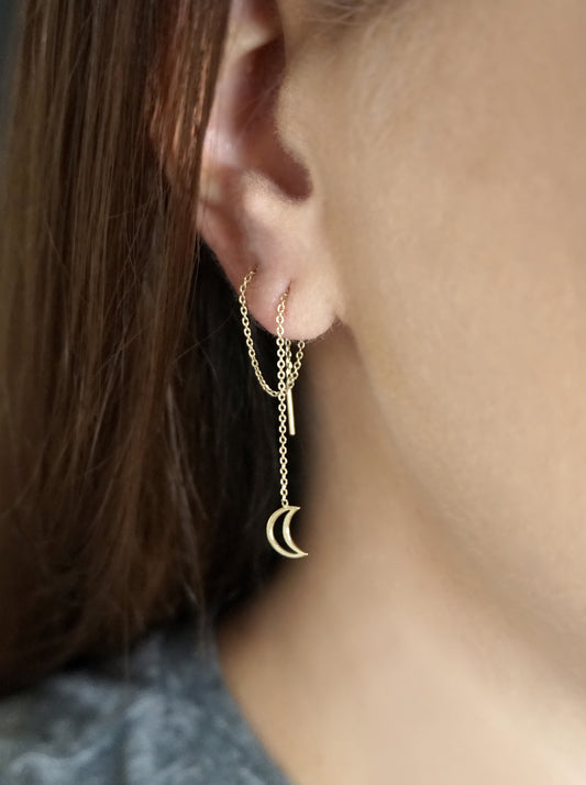 woman wearing gold threader earring with tiny a crescent moon pulled through two piercings