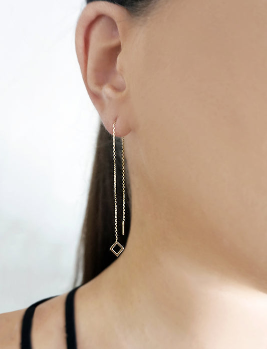 woman wearing gold threader pull through earring with tiny rhombus