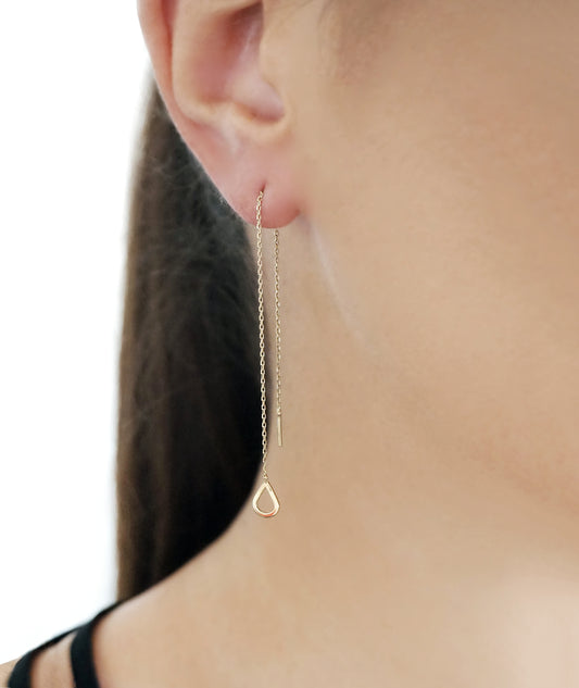 woman wearing yellow gold threader pull through earring with a tiny teardrop
