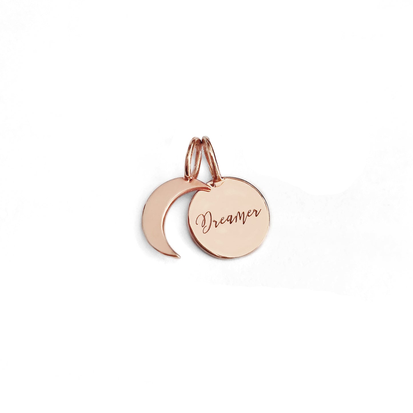 two small solid rose gold charms, a crescent moon and a personalized disc