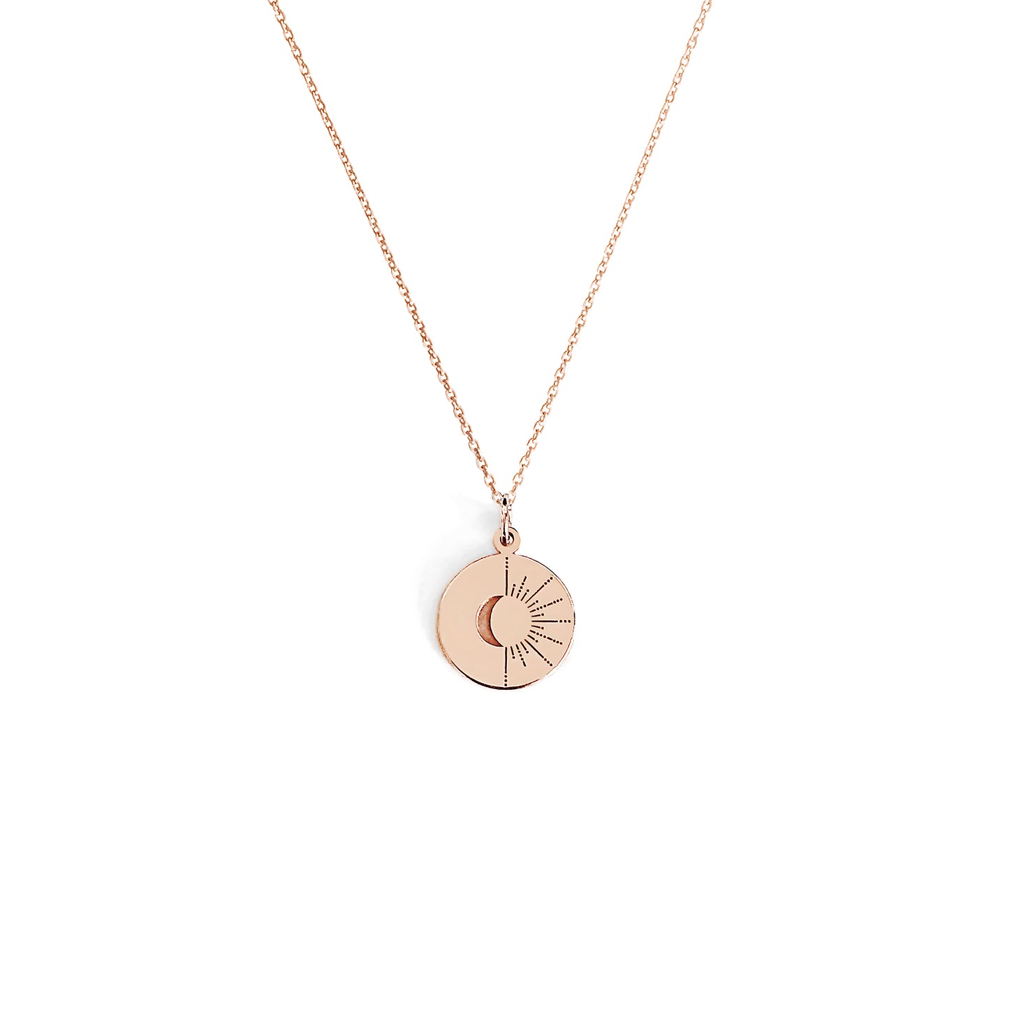 solid rose gold disc pendant necklace engraved with a crescent moon and sun rays on a white background