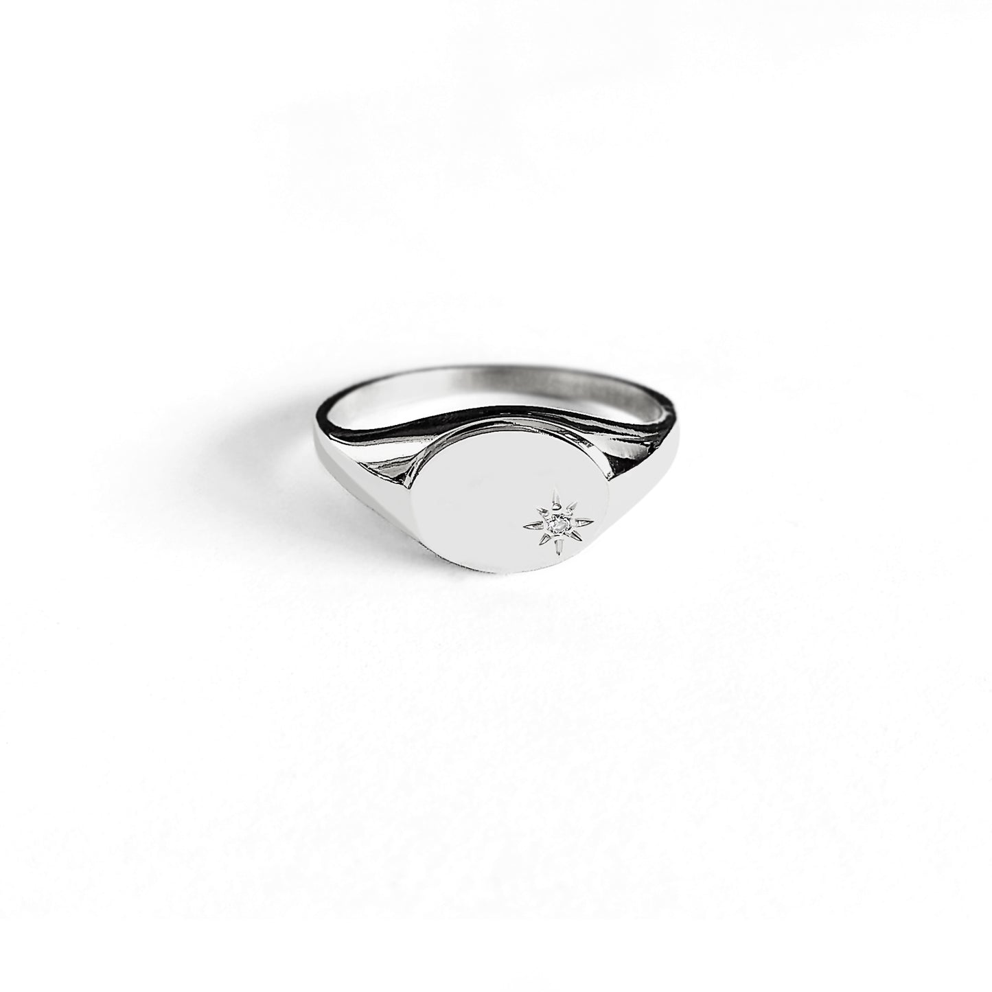 dainty solid white gold oval signet ring set with a tiny diamond with a polaris star setting