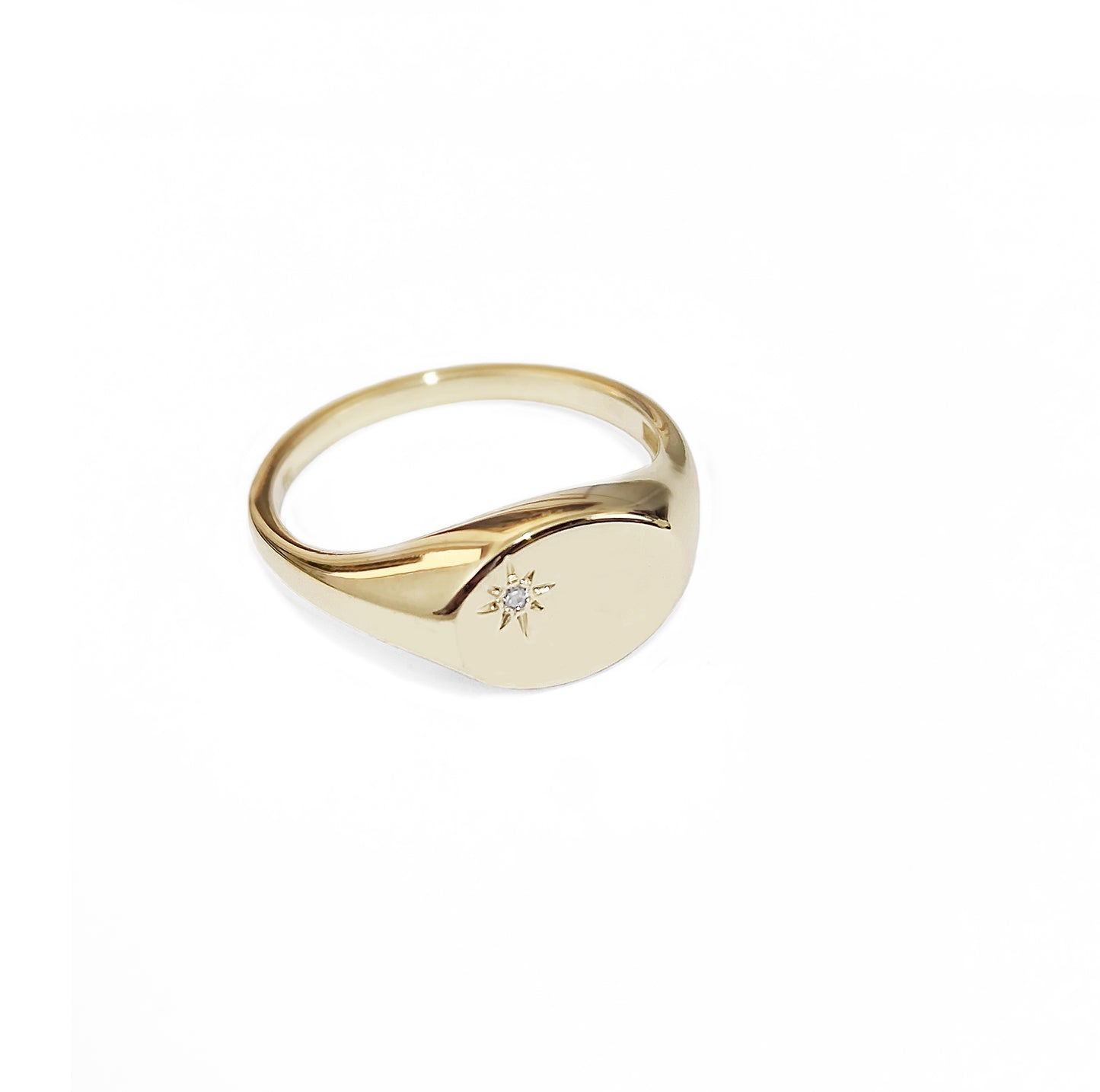 side view of dainty yellow gold oval signet ring set with a tiny diamond with a polaris star setting
