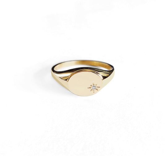 dainty solid yellow gold oval signet ring set with a tiny diamond with a polaris star setting