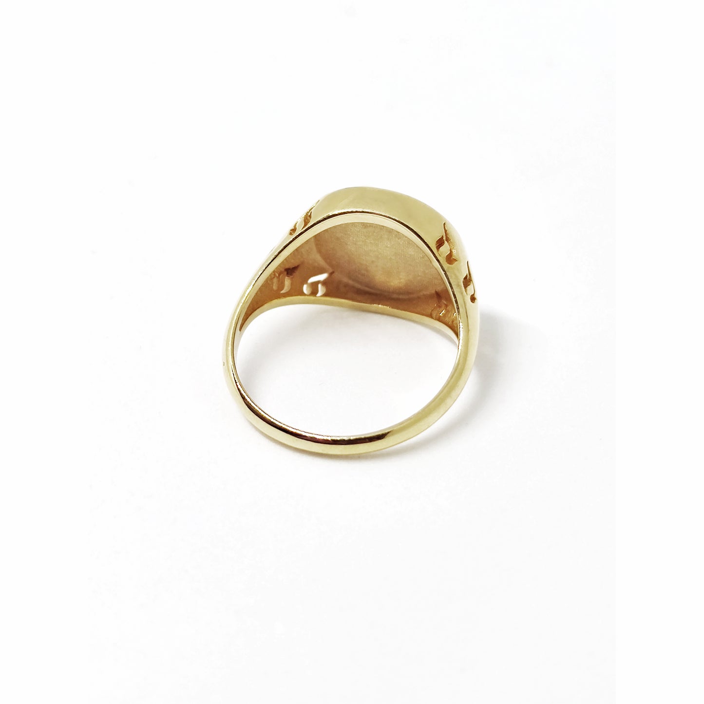 view of the semi hollow back of a gold round signet ring engraved with a phoenix firebird rising with flame cutouts around the base of the ring's head
