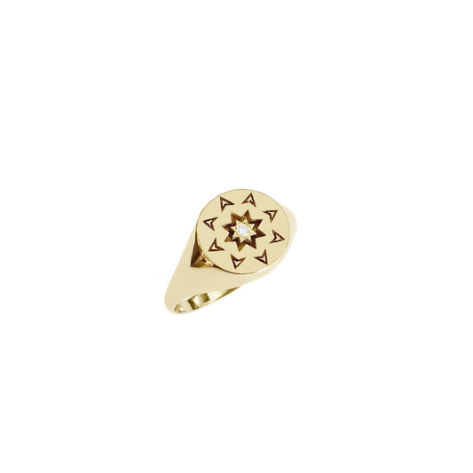solid yellow gold round signet ring with a north star starburst design and a diamond on the center