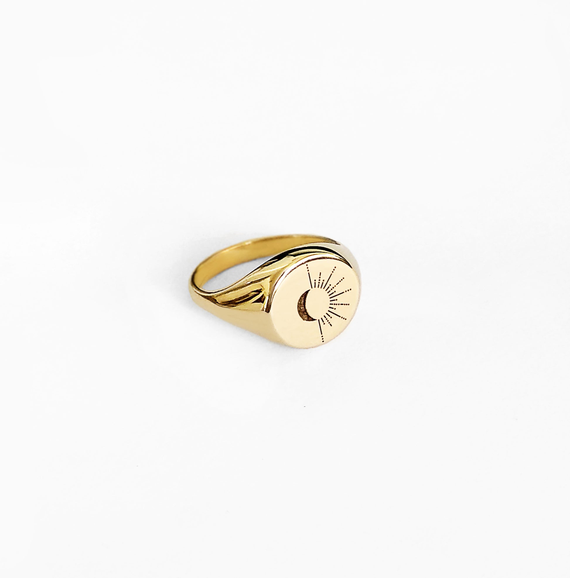 side view of solid yellow gold round signet ring engraved with the sun and moon