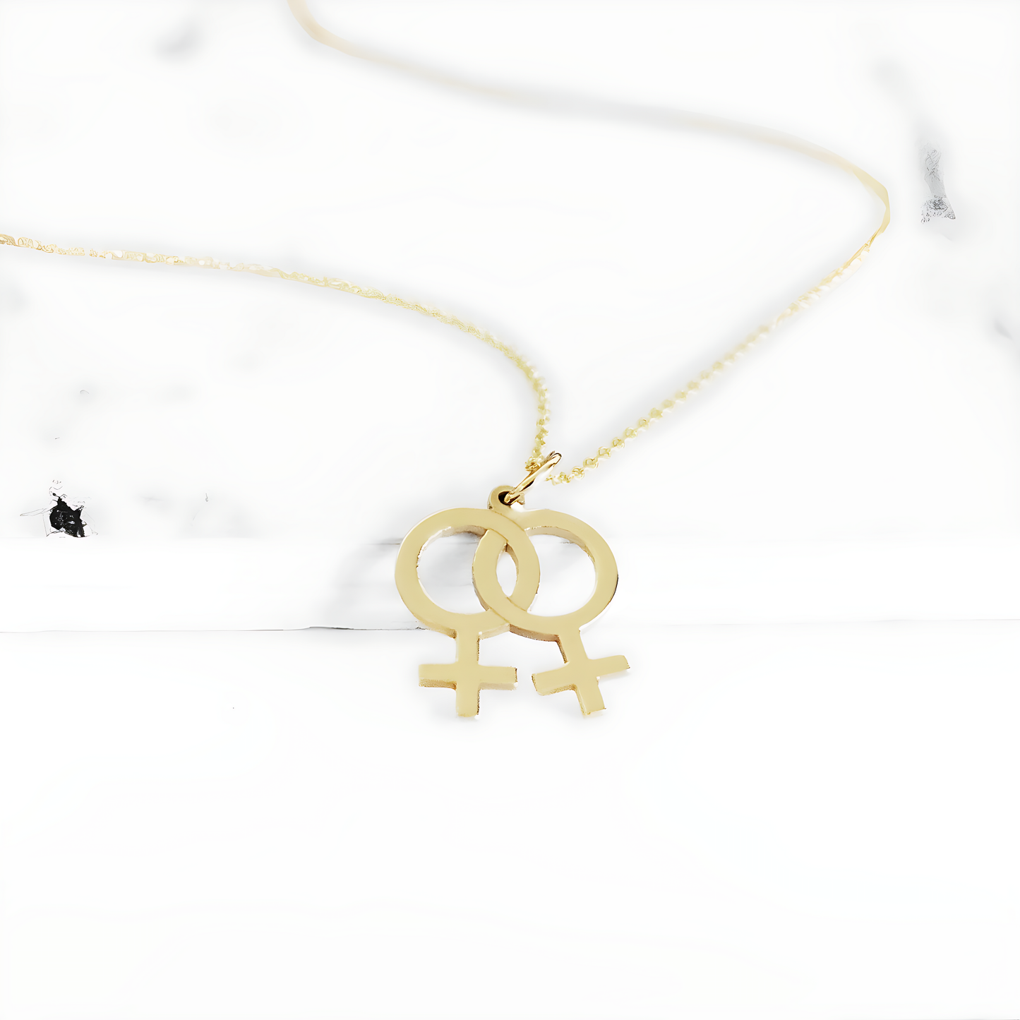 solid gold necklace with a small double female/venus lesbian symbol pendant