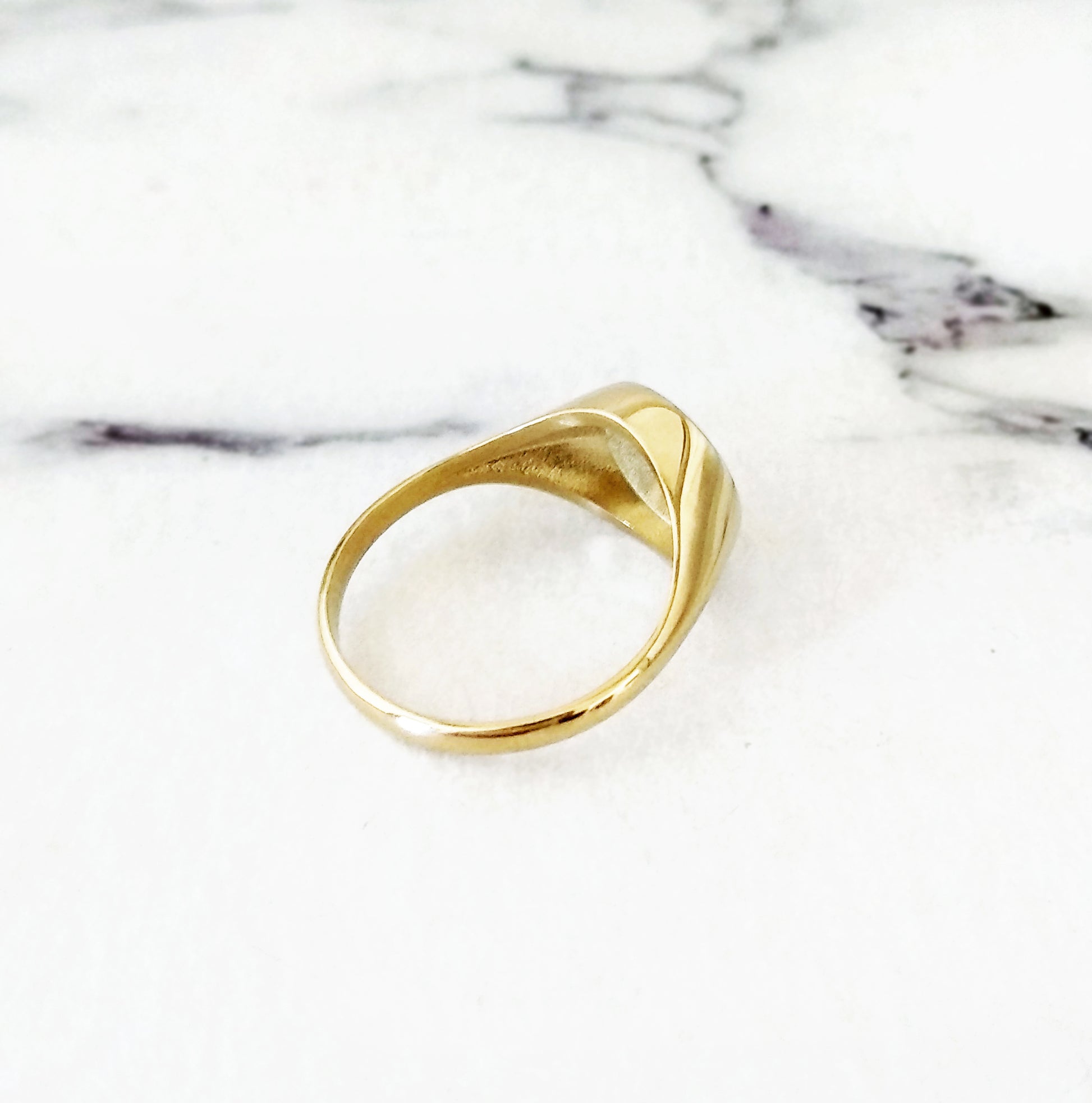 view of the semi hollow back of solid yellow gold round signet ring engraved with the sun and moon