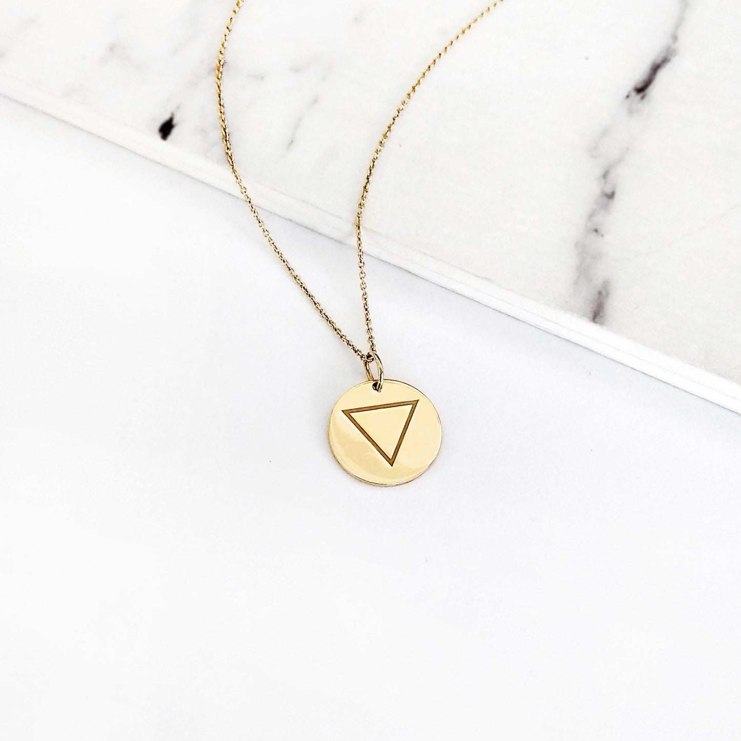 yellow gold necklace with a 14mm disc pendant engraved with the water element