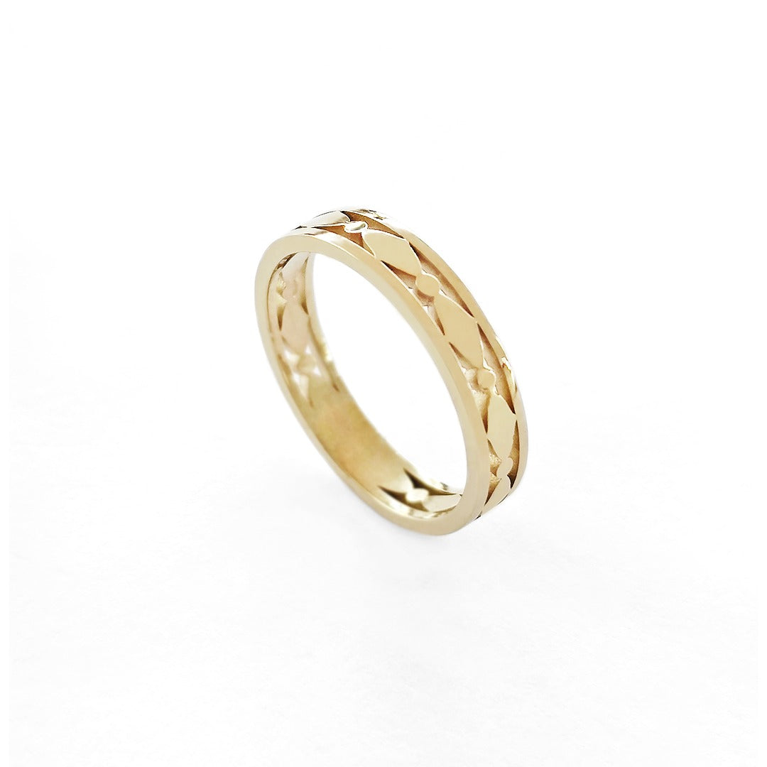 Gold ring with an art deco design on a white background