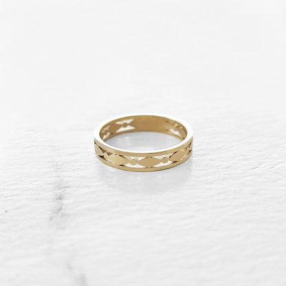 3.7mm solid yellow gold art deco wedding ring on a marble surface