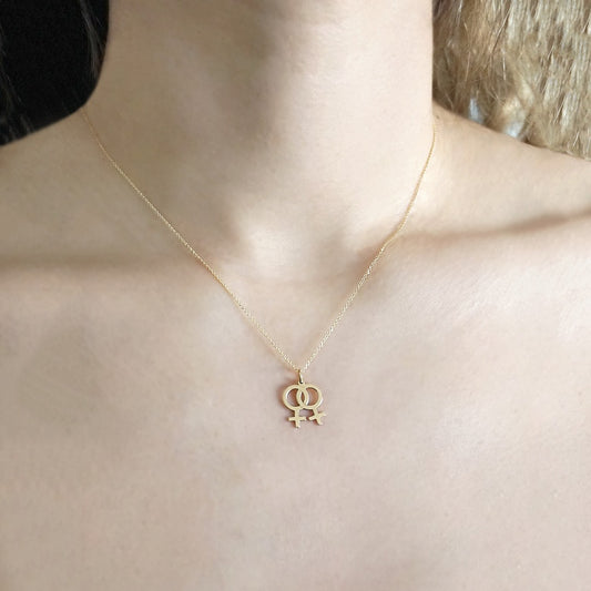 Female wearing solid gold necklace with a small double female/venus lesbian symbol pendant