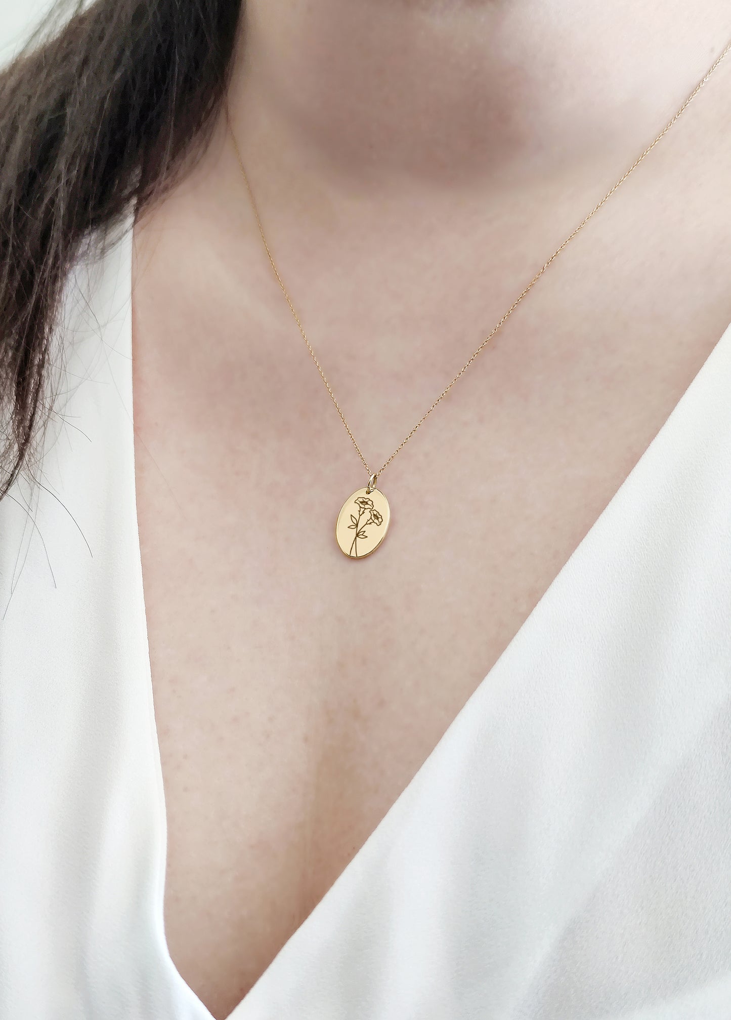 female wearing gold oval pendant necklace engraved with Morning Glory birth flower of September 