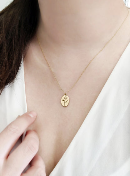 female wearing solid yellow gold oval pendant necklace engraved with a Water Lily the birth flower of July 