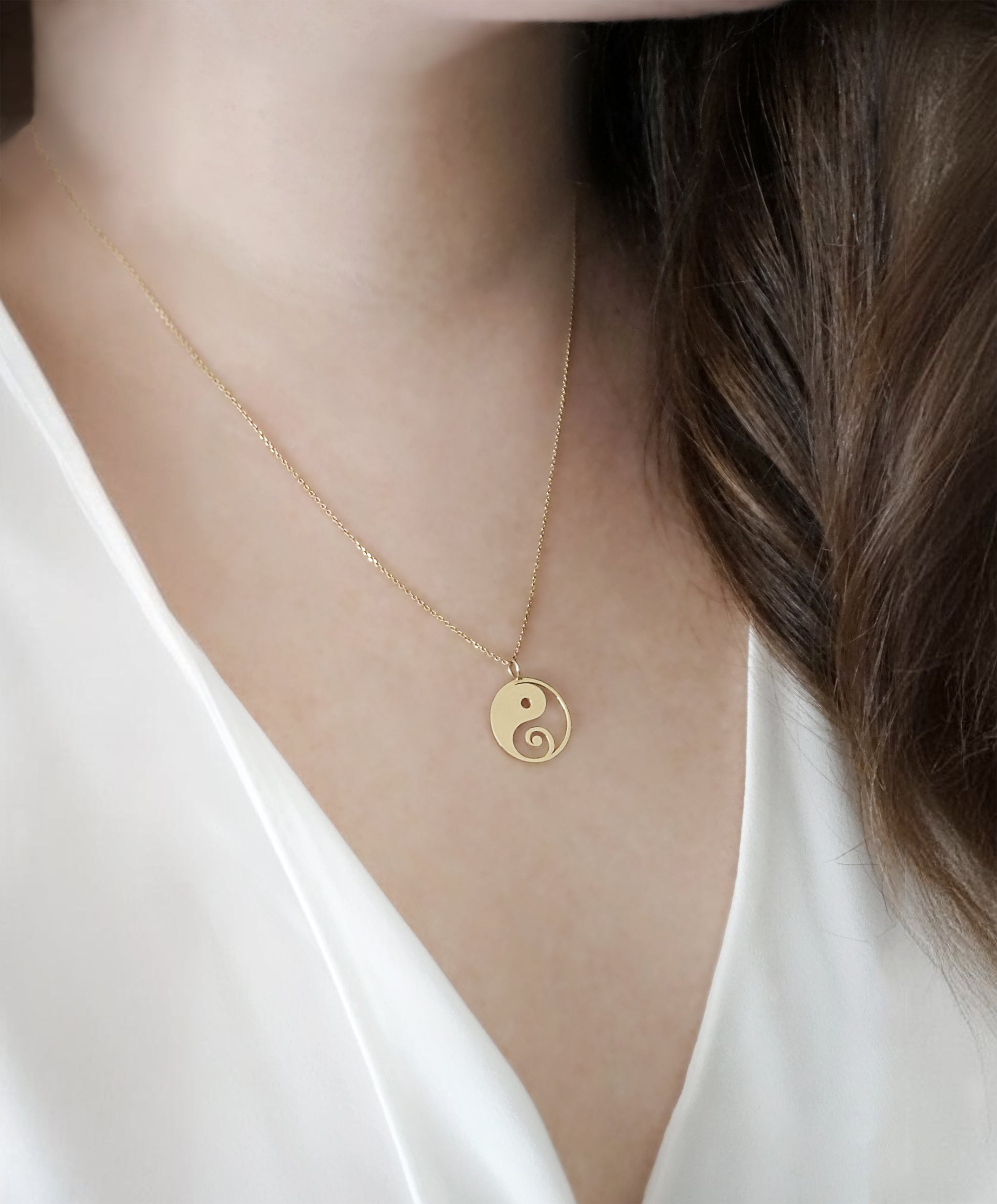close up of a woman's neck wearing a solid yellow gold necklace with a 16mm yin yang pendant