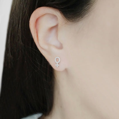 female wearing small solid white gold female/Venus symbol stud earrings
