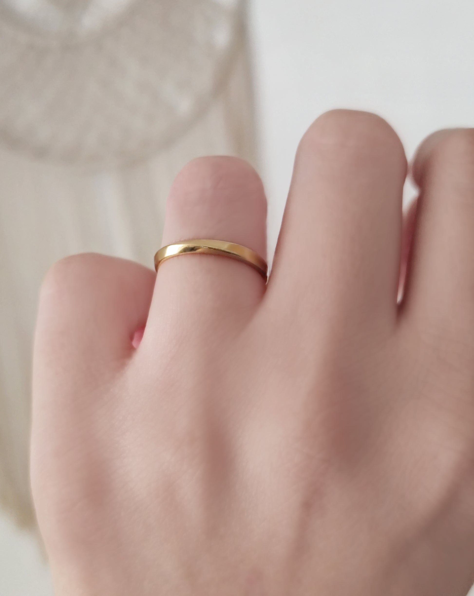 female wearing a solid gold 2.5mm mobius ring on her ring finger