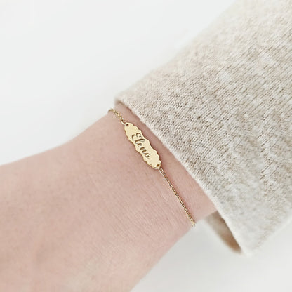 woman wearing gold bracelet with a vintage baroque inspired bar engraved with a name
