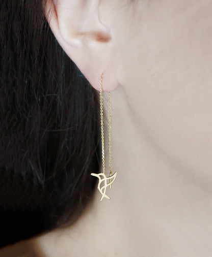 Female wearing yellow gold hummingbird threader earrings