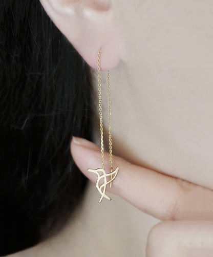 Person wearing yellow gold hummingbird threader earrings