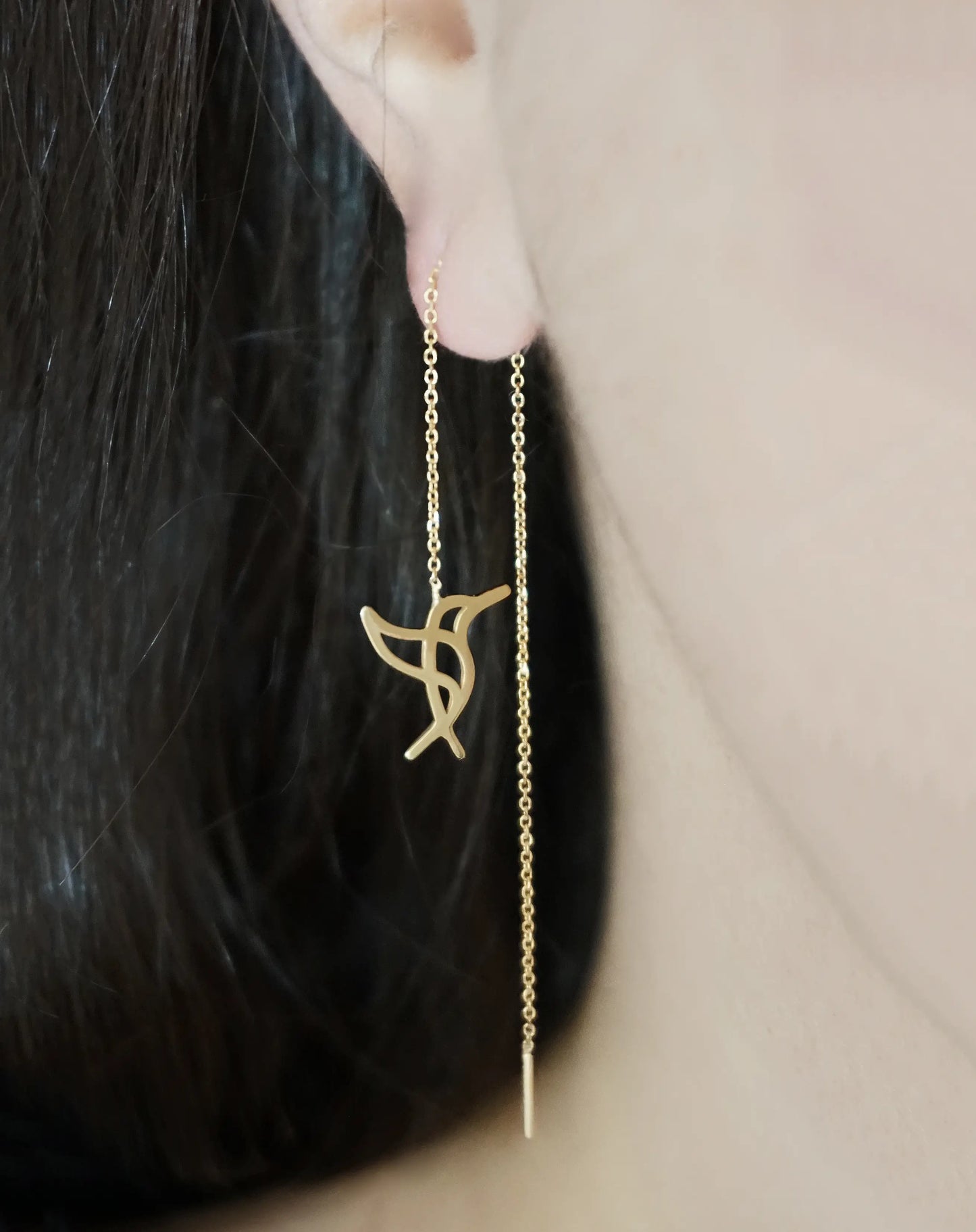 Female wearing yellow gold hummingbird threader pull through earrings