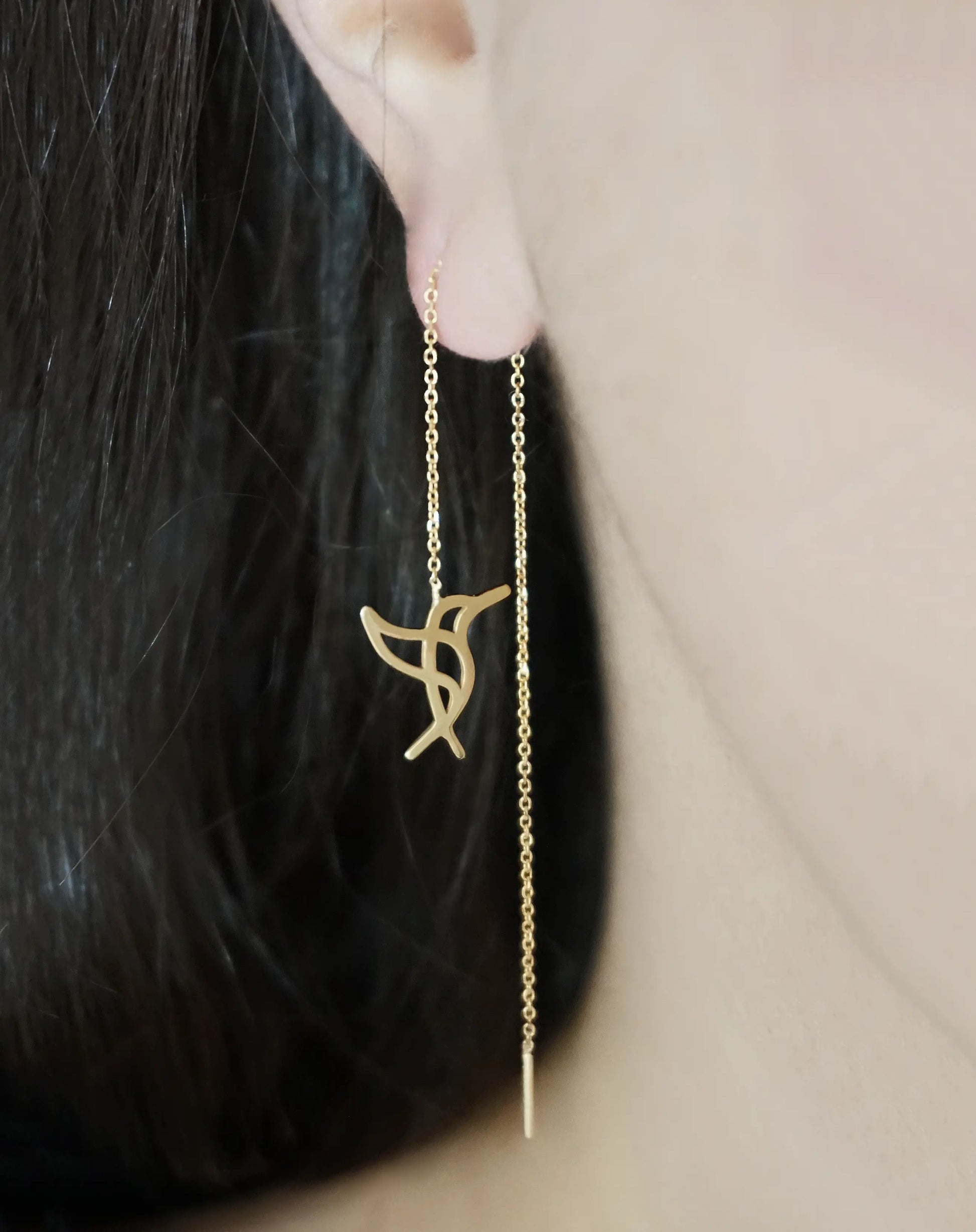 Female wearing yellow gold hummingbird threader pull through earrings