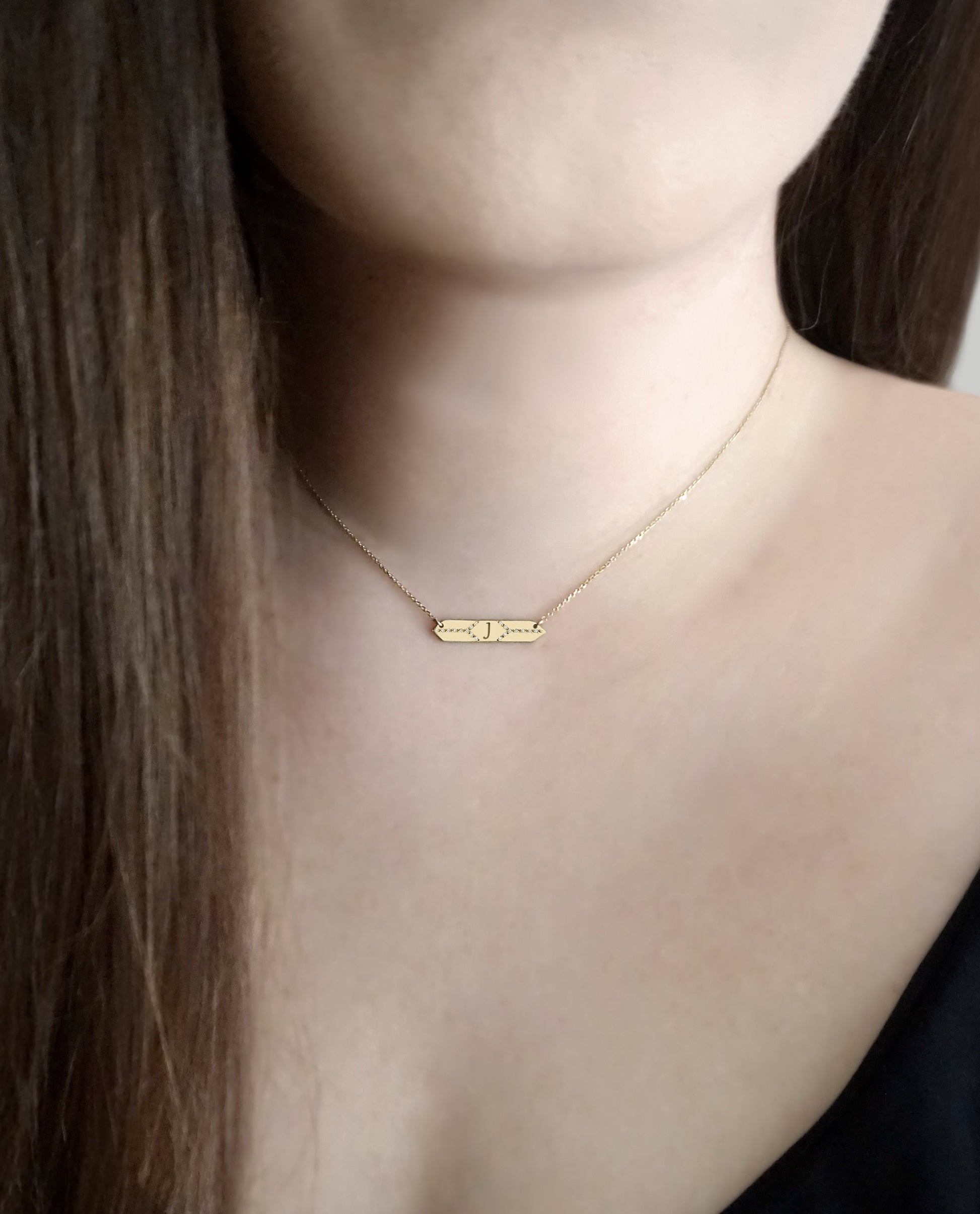 female wearing a hexagon bar necklace set with white diamonds and personalized with a custom monogram