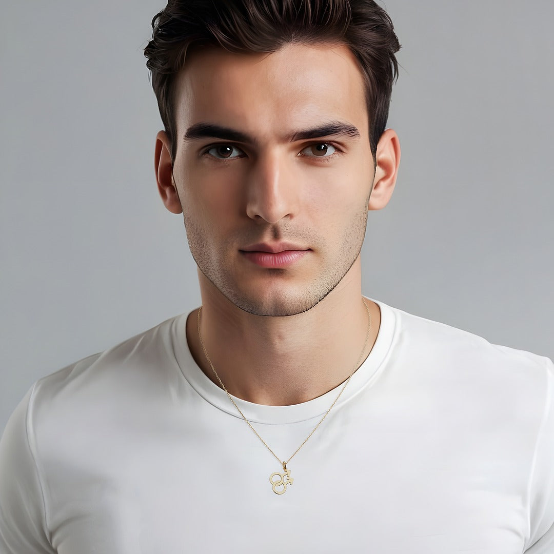 Man wearing a white t-shirt and a gold necklace with a double mars symbol pendant against a gray background