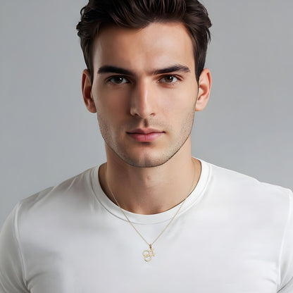 Man wearing a white t-shirt and a gold necklace with a double mars symbol pendant against a gray background