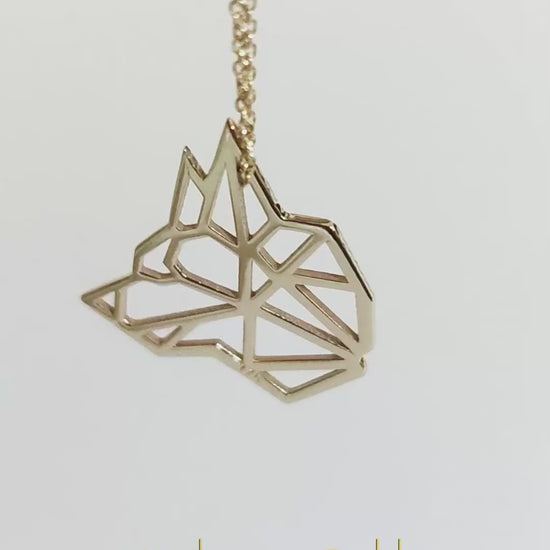 video showcasing a solid gold necklace with an origami inspired wolf pendant
