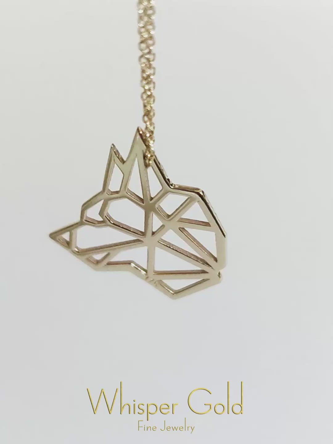video showcasing a solid gold necklace with an origami inspired wolf pendant