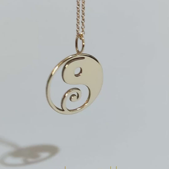 video of a solid yellow gold necklace with a 16mm yin yang pendant