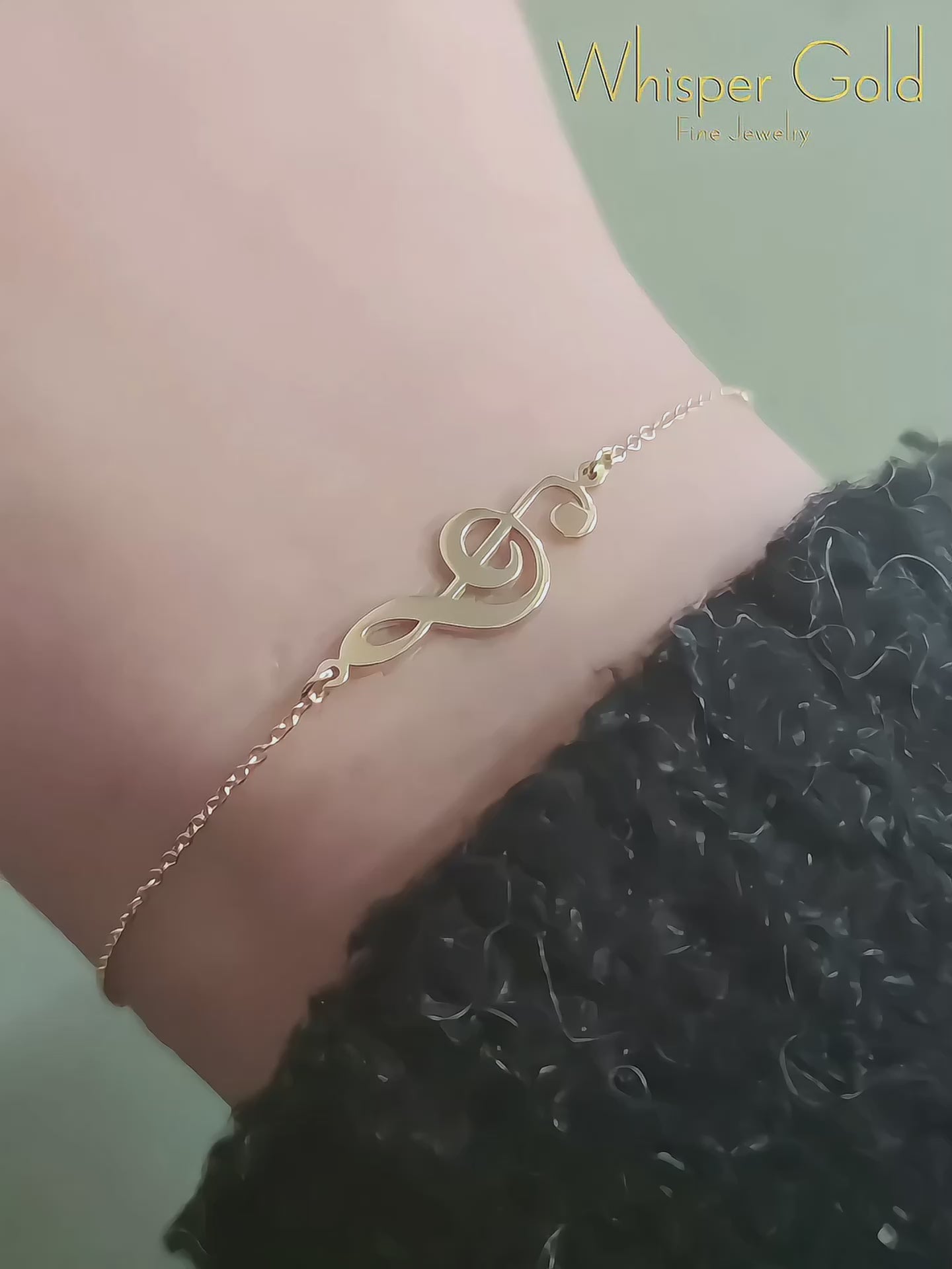 video of a woman's wrist wearing a solid yellow gold treble clef music charm bracelet