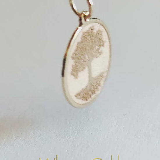 a close up video of a 9k gold disc pendant engraved with the Tree of life