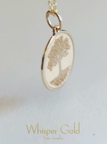 a close up video of a 9k gold disc pendant engraved with the Tree of life