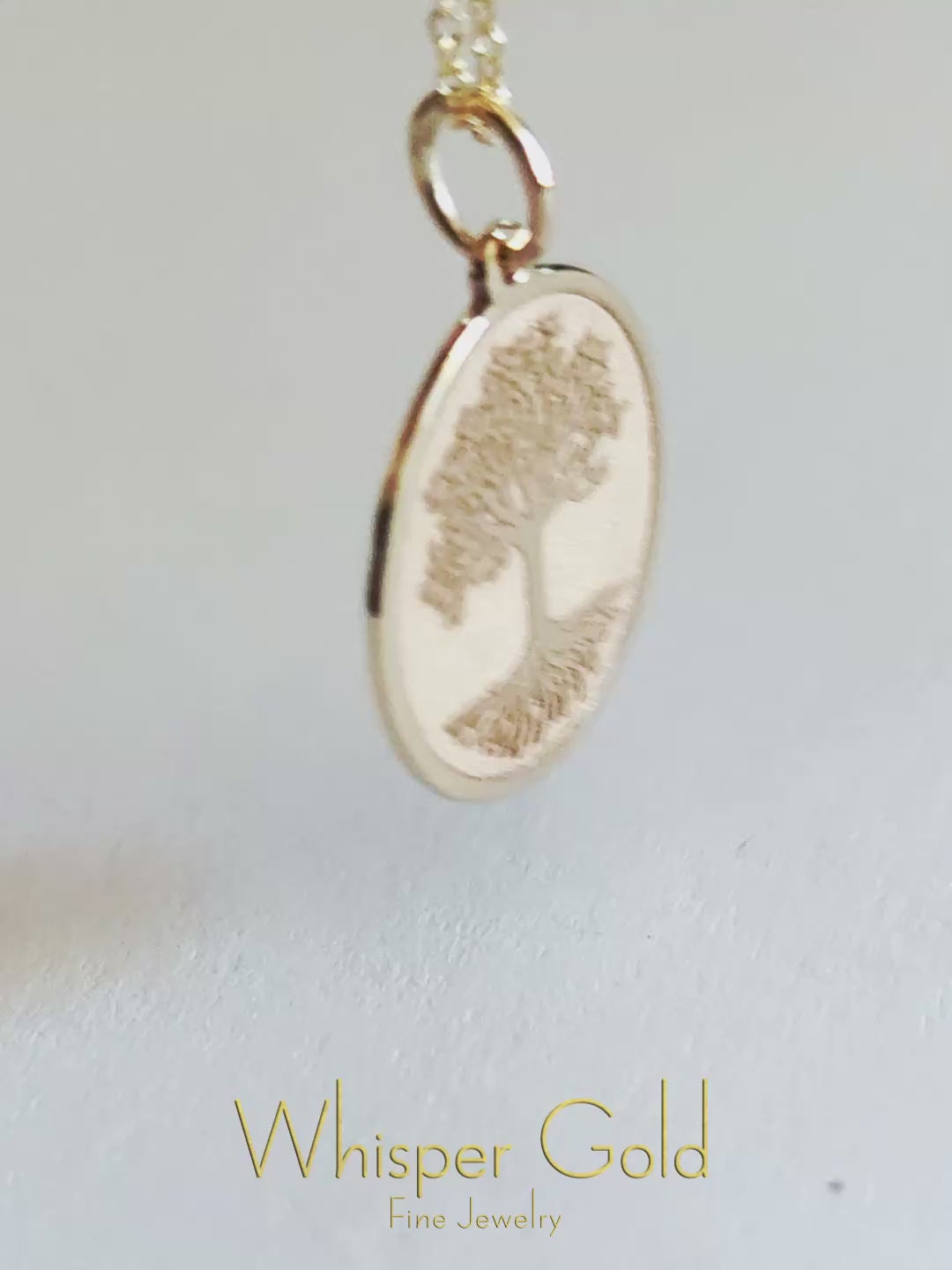 a close up video of a 9k gold disc pendant engraved with the Tree of life
