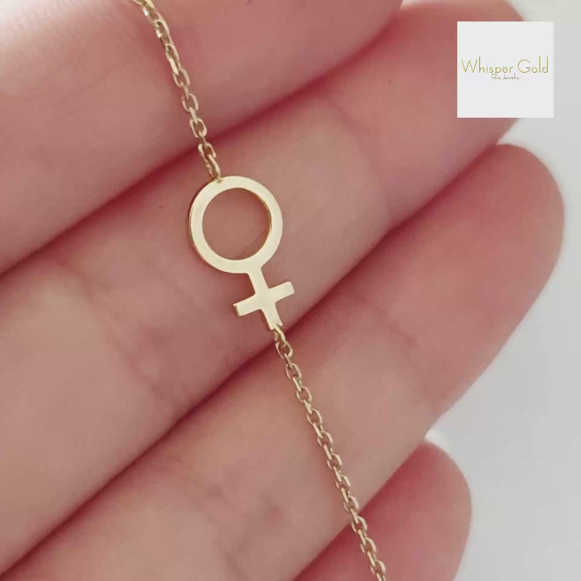 a video showcasing a solid gold bracelet with a small venus female symbol charm 