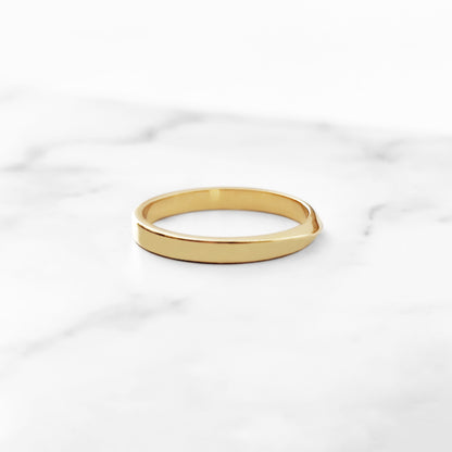 side view of a polished solid yellow gold thin mobius wedding ring 