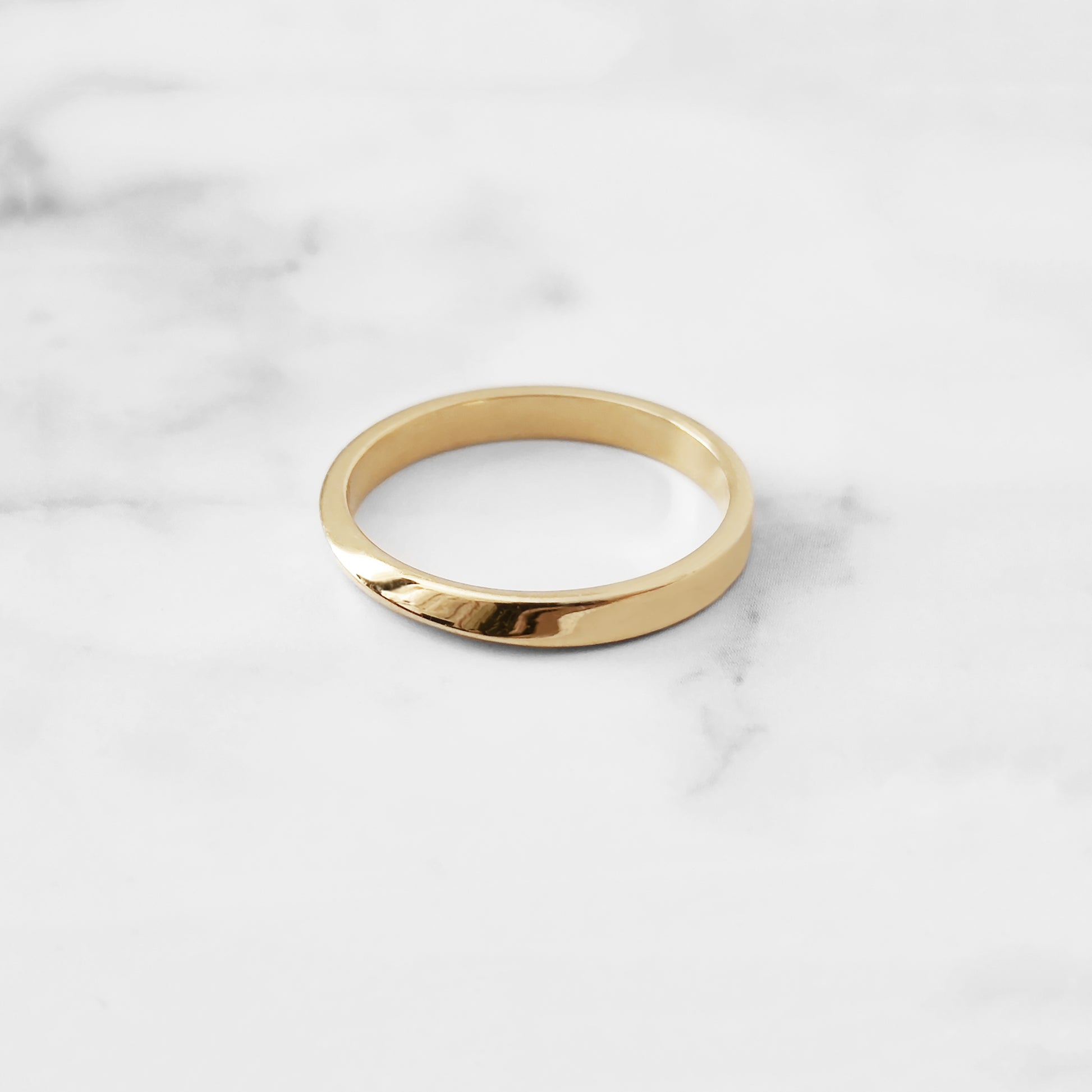 side top view of a solid yellow gold thin mobius wedding ring 